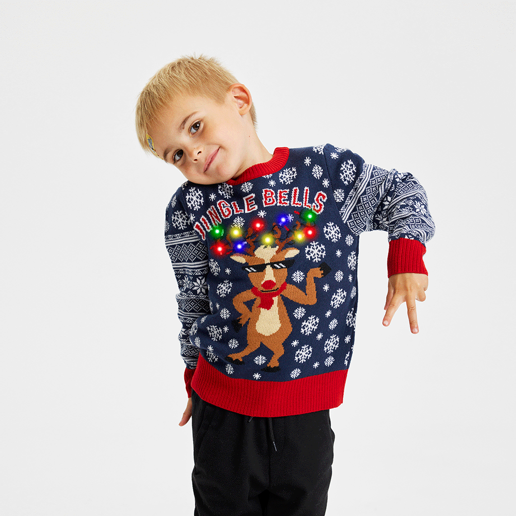 En sødt barn iført en blå julesweater med lys på.